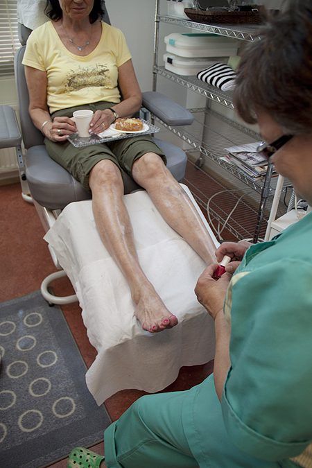 Hoitaja tekee jalkahoitoa asiakkaalle